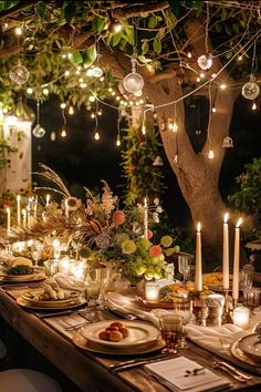 an outdoor dinner table is set with candles, plates and place settings for the meal