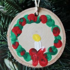 an ornament hanging from a christmas tree decorated with red and green poinsettis