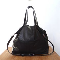 Leather bag in black, soft and big. Made in Italian leather. Really oversized. Great as a leather work bag. Bag is very roomy and comfortable. Perfect to carry many things: Laptop, magazines, books and more. The front decorative stitching. Bag Zippered. Handles 58 cm. Complete with a long strap, you can adjust the length to be worn on the arm, max. l. 110 cm. Leather soft, genuine leather, high quality. In the middle the lining; inside a large zip pocket and a smaller leather pocked on the phone Black Soft Leather Satchel Weekender Bag, Black Soft Leather Weekender Shoulder Bag, Black Soft Leather Shoulder Weekender Bag, Black Soft Leather Weekender Bag For Daily Use, Black Leather Weekender Bag With Removable Pouch, Leather Work Bag, Usa Bag, Decorative Stitching, Leather Work