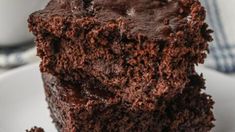 a piece of chocolate cake sitting on top of a white plate next to a cup