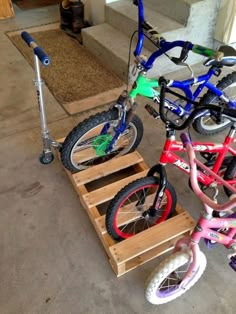 three bikes are parked on wooden pallets in the garage