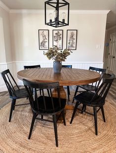 a dining room table with four chairs and a potted plant on the top of it