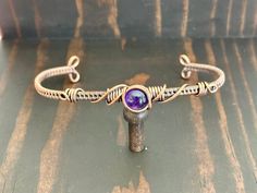 a bracelet with a purple stone on it