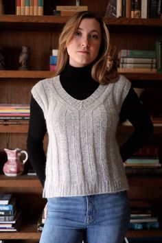 a woman standing in front of a bookshelf with her hands on her hips