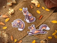 two stickers with an image of a fox on them and some nuts scattered around