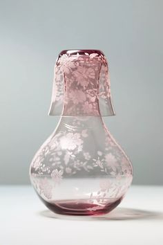 a pink glass vase sitting on top of a table