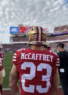 a football player wearing a red and white uniform on the sidelines at a game