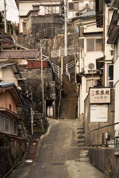 an alley way with stairs leading up to the top and down on both sides, in front of buildings