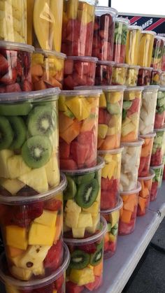 many plastic containers filled with different types of fruit