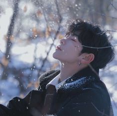 a person standing in the snow with their eyes closed