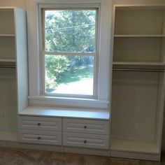 an empty room with some shelves and a window