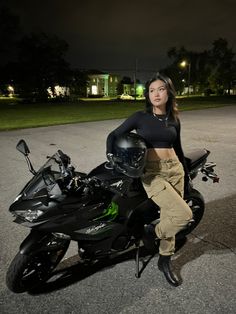 a woman sitting on top of a black motorcycle