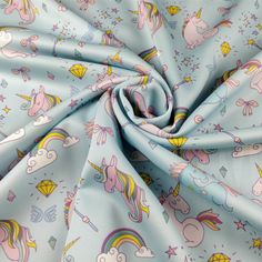 a blue fabric with unicorns, stars and kites printed on the back in pastel colors