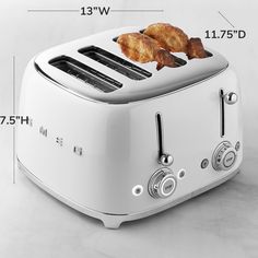 a white toaster with two pieces of bread on it and measurements for the size