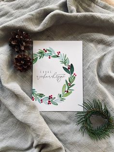 a christmas card with pine cones and berries on it next to a fir tree branch