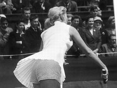 a woman is playing tennis in front of an audience