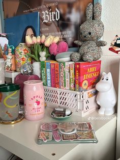 there are many books and toys on the table with it's shelf full of them