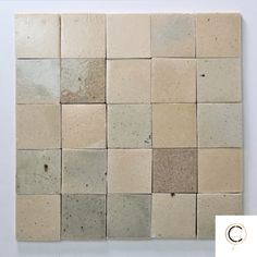 a white wall with several square tiles on it