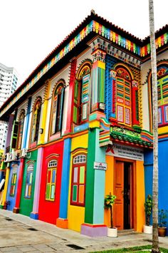 a multi - colored building with many windows and shutters on the front is painted in different colors