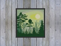 a cross stitch picture of trees in the woods at sunset, on a wooden fence