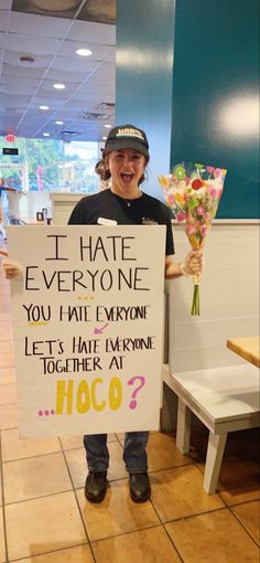 a man holding a sign that says i hate everyone