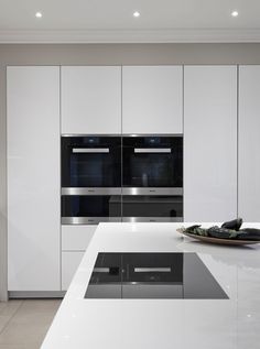 a modern kitchen with white cabinets and stainless steel appliance, including an oven