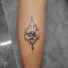 a black and white photo of a flower tattoo on the right leg, with an arrow in the middle