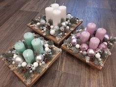 three wooden trays filled with candles and christmas decorations on top of a wood floor