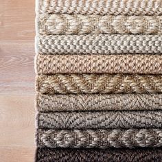 a pile of woven rugs sitting on top of a wooden floor