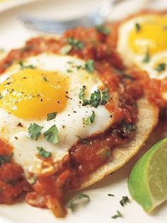 two eggs on pita bread with salsa and lime