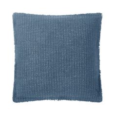 a blue pillow with fraying on the front and back side, against a white background