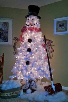 a white christmas tree decorated with lights and a snowman