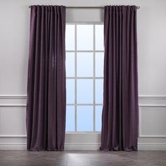 an open window with purple curtains in front of it and a white wall behind it