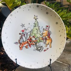 a plate with winnie the pooh and tigger around a christmas tree