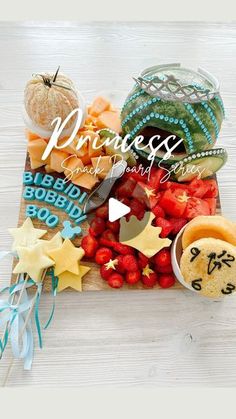 a wooden cutting board topped with fruit and veggies