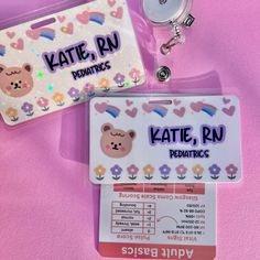 two id badges are sitting next to each other on a pink surface with flowers and hearts