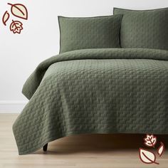 a bed covered in green bedspread and pillows