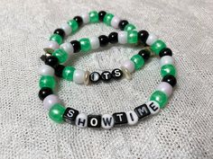 "This cute beaded bracelet sets is calling all Beetlejuice fans!  From the infamous cult classic, the double set features one of his famous lines:  \"It's showtime!\"  The simple set is made with signature movie color pony beads and is accented with small pearl bead slices as well as metallic silver stars.   Enjoy a multitude of beads on this stretchy double set and make a statement. The cording is reinforced with E6000 glue at the knot." Kandi Bead Ideas, Pony Bead Bracelets Ideas, Halloween Kandi, Cute Beaded Bracelet, E6000 Glue, Star Pearl, Diy Kandi Bracelets, Pony Bead Bracelets, Double Bracelet