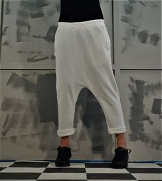 Baggy White Harem Pants With Elastic Waistband, White Loose Fit Ankle-length Harem Pants, White Ankle-length Harem Pants With Loosely Fitted Hips, Trendy Sweatpants With Loosely Fitted Hips, Ankle-length, White Cotton Tapered Leg Harem Pants, Trendy White Pants With Side Pockets, White Baggy Cargo Pants With Hip Pockets, Trendy Baggy Trousers, Baggy High-waisted Pants With Elastic Waistband