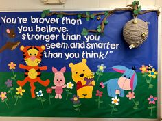 a winnie the pooh bulletin board with flowers and other cartoon characters in front of it