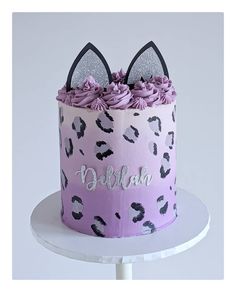 a pink and black cake with ears on top