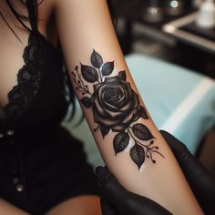 a woman with a black rose tattoo on her arm