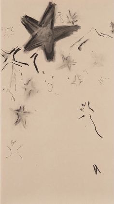 a black and white photo of a bird flying in the sky with dandelions