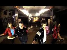 three young men in black and red jackets are walking through an abandoned building with graffiti on the walls