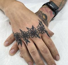 a hand with black flowers on it