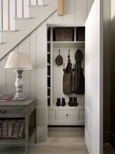 an entry way with white walls and wooden stairs