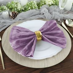 there is a plate with a purple bow on it and silverware next to it