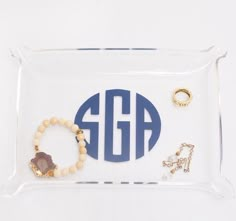 an acrylic tray with monogrammed jewelry and bracelets on the bottom