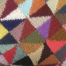 a multicolored knitted blanket is shown in close up, showing the diagonals