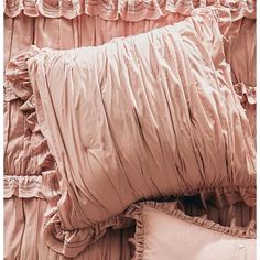 a bed with ruffled sheets and pillows